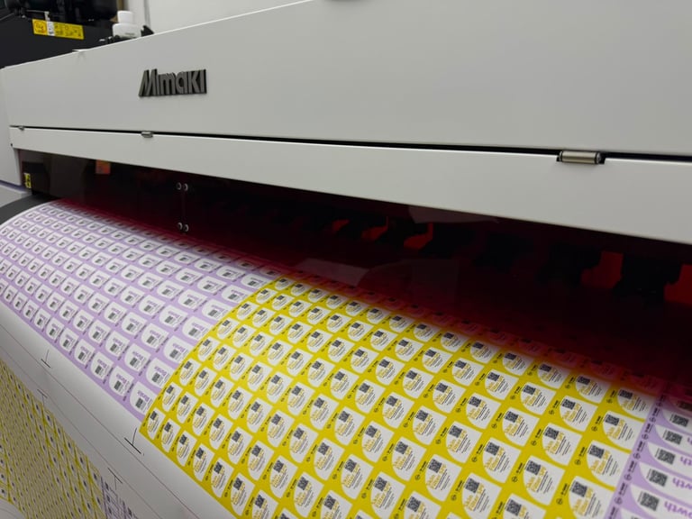 Alimask industrial printer with yellow and purple printed sheet material running through it on a production floor